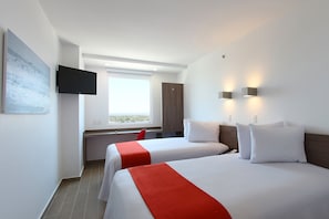 A hotel room with two beds, a TV mounted on the wall, a window with a view, and a desk with a chair. - One La Paz Hotel (La Paz)