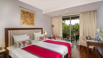 A hotel room with two beds, a balcony with a table and chairs, and a large window with curtains.