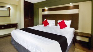 A hotel room with a large bed, a nightstand, a dresser, and a mirror. - Hotel La Fuente, Saltillo (Saltillo)