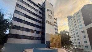 A hotel with a modern design, featuring a prominent entrance and a terrace area.