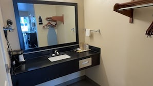A bathroom with a black sink, a mirror, and a towel rack. - Garden Inn and Suites Little Rock (Little Rock)