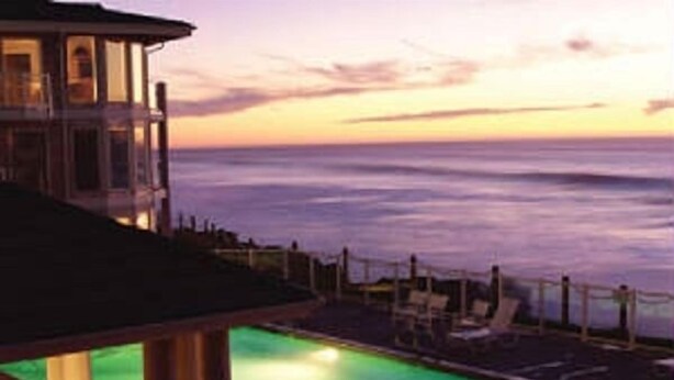 Piscina com vista para o oceano ao pôr do sol.