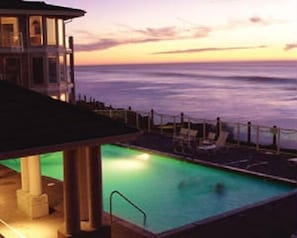 A swimming pool with a view of the ocean at sunset. - Whale Pointe at Depoe Bay (Depoe Bay)