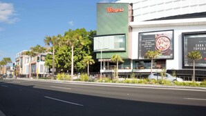 A street view with a building featuring a 'Westfield' sign, adjacent to a restaurant with 'Italian Kitchen' and 'Zara Topshelf' advertisements. - Metro Hotel Miranda (Miranda)