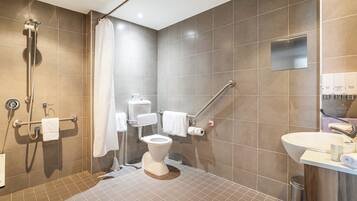 A modern bathroom with a shower, toilet, and sink.