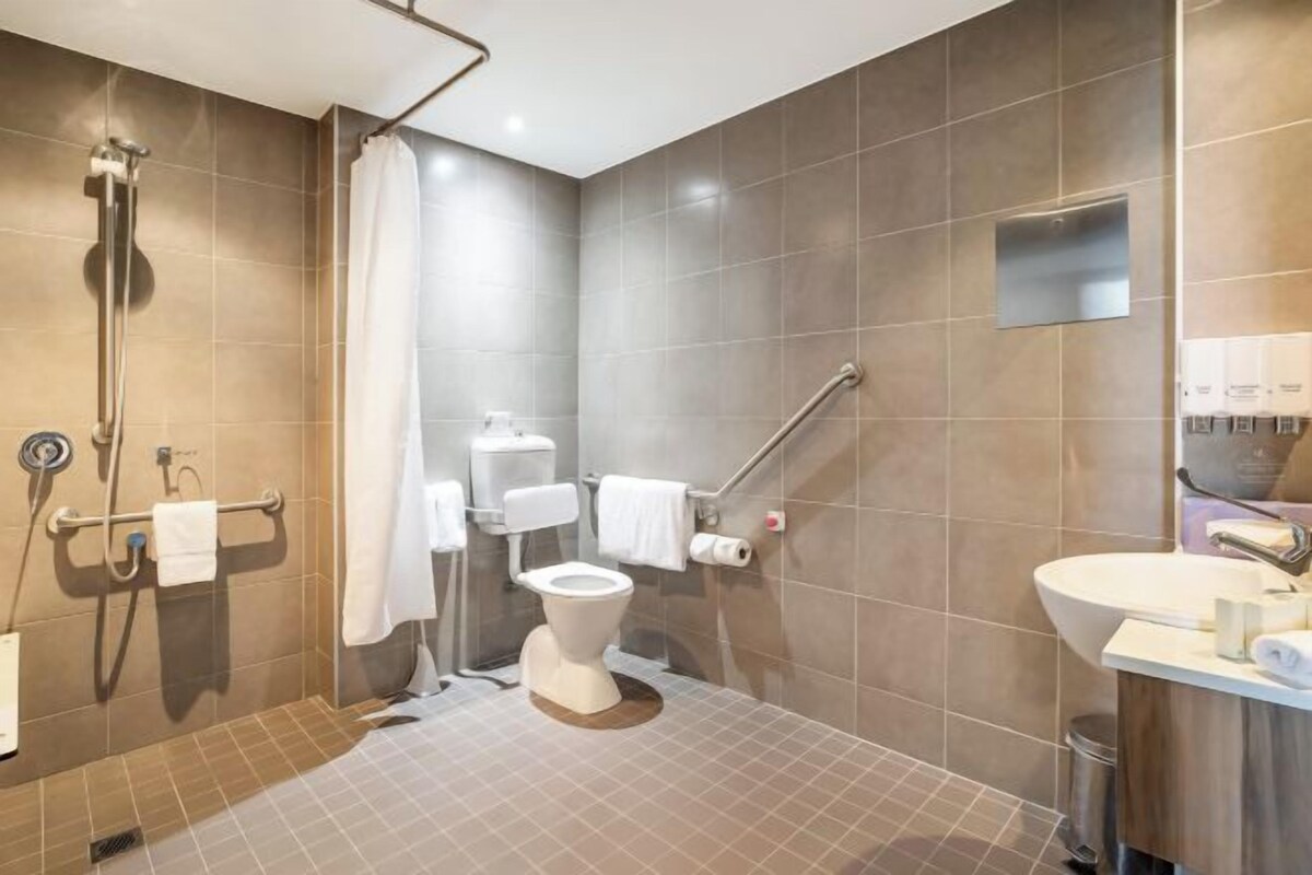 Un baño moderno con ducha, inodoro y lavabo.