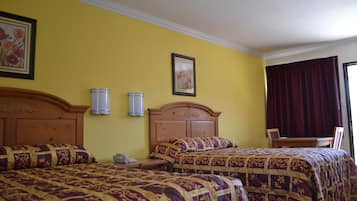 Habitación de hotel con dos camas, cabecera de madera, mesita de noche, teléfono y ventana con cortinas.