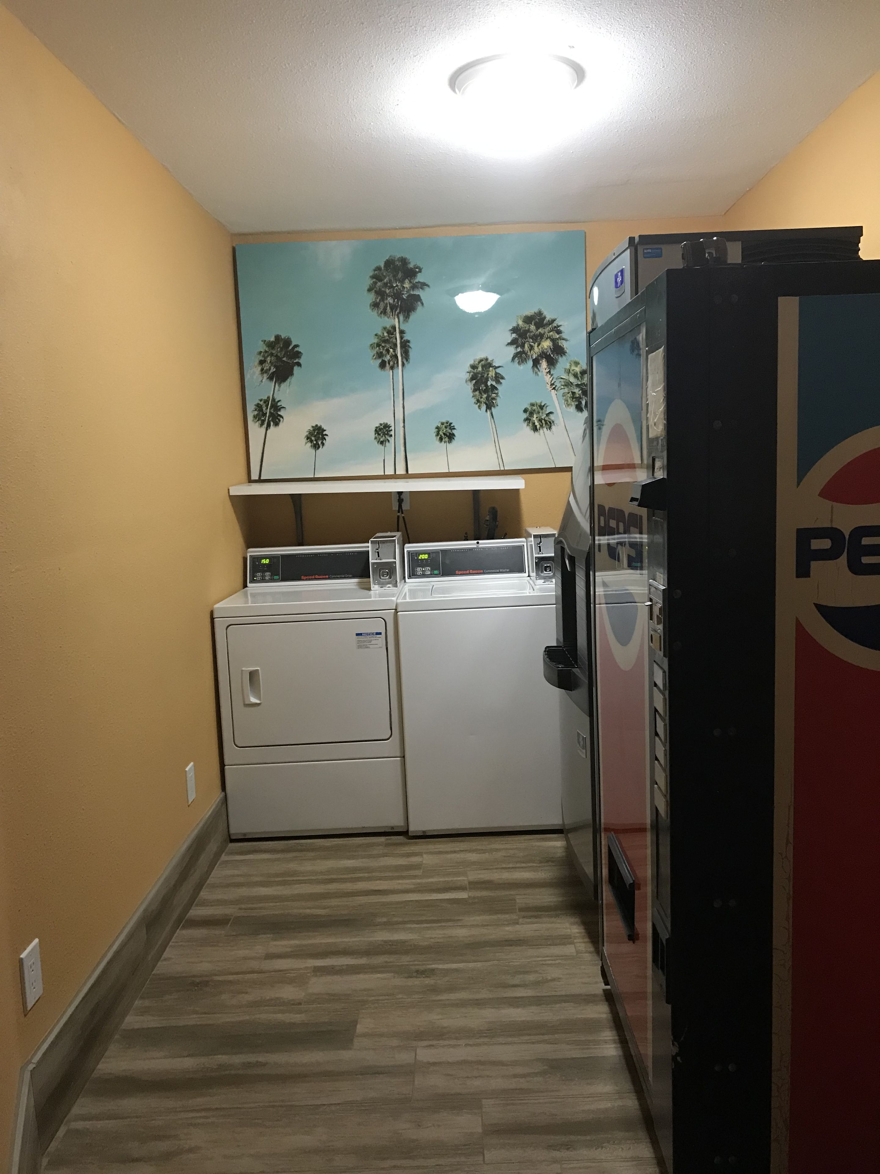 A laundry area with a washing machine, dryer, and a refrigerator.