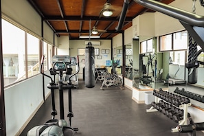 A gym with cardio machines, a punching bag, and dumbbells. - Baja Inn Hoteles La Mesa (Tijuana)
