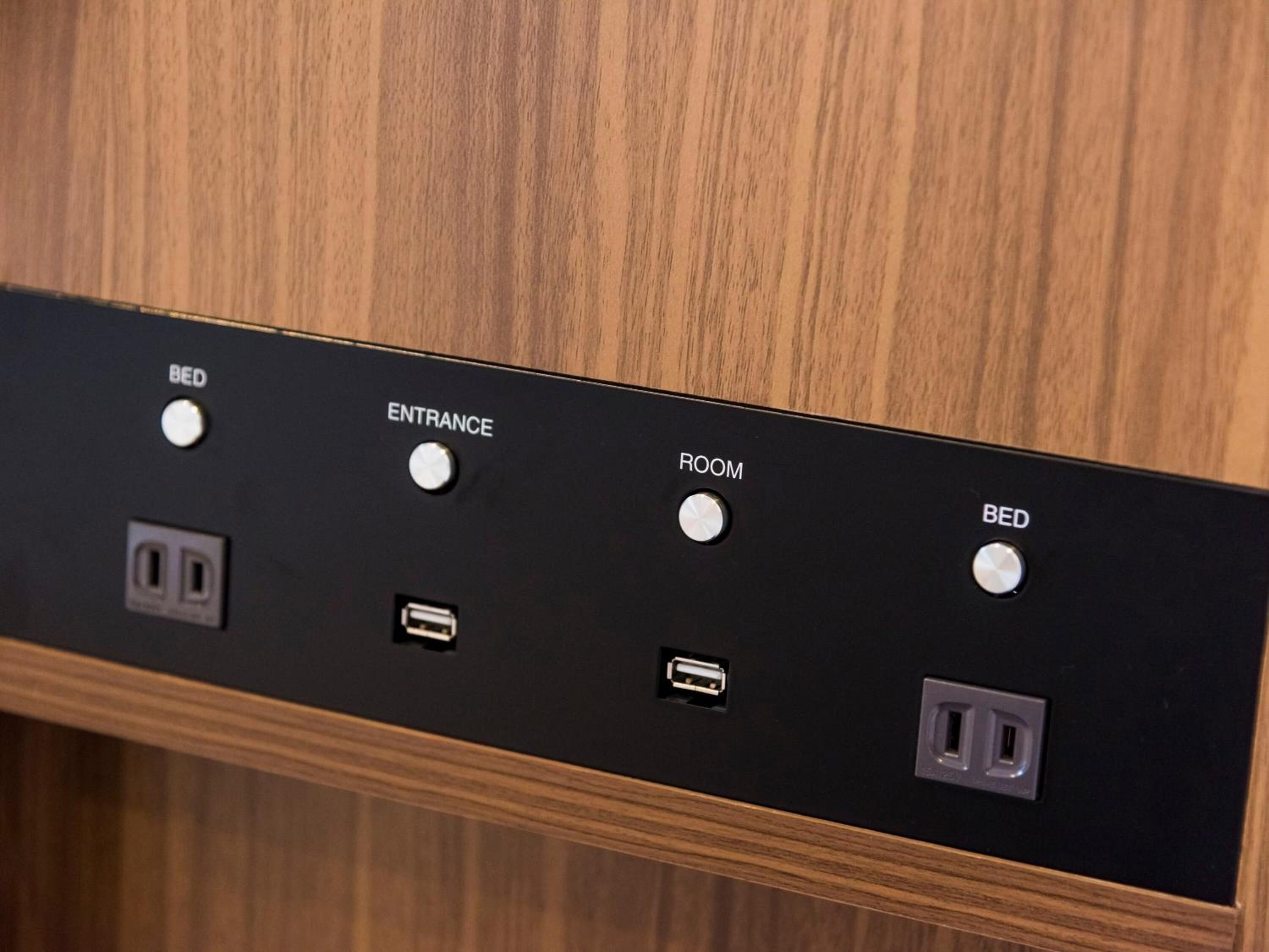 Un panneau de commande doté de boutons clairement étiquetés pour les fonctions « LIT », « ENTRÉE », « CHAMBRE » et à nouveau « LIT », ainsi qu’un port USB et une prise de courant.