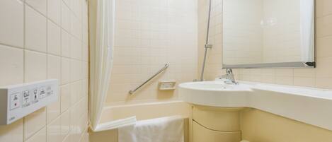 A bathroom with a toilet, sink, shower, and a mirror.
