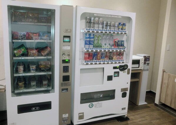 A vending machine with various snacks and drinks, including chips, chocolate, and bottled water.