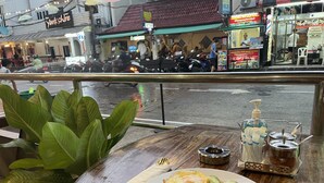 Uma mesa com um prato de comida, um guardanapo e condimentos.