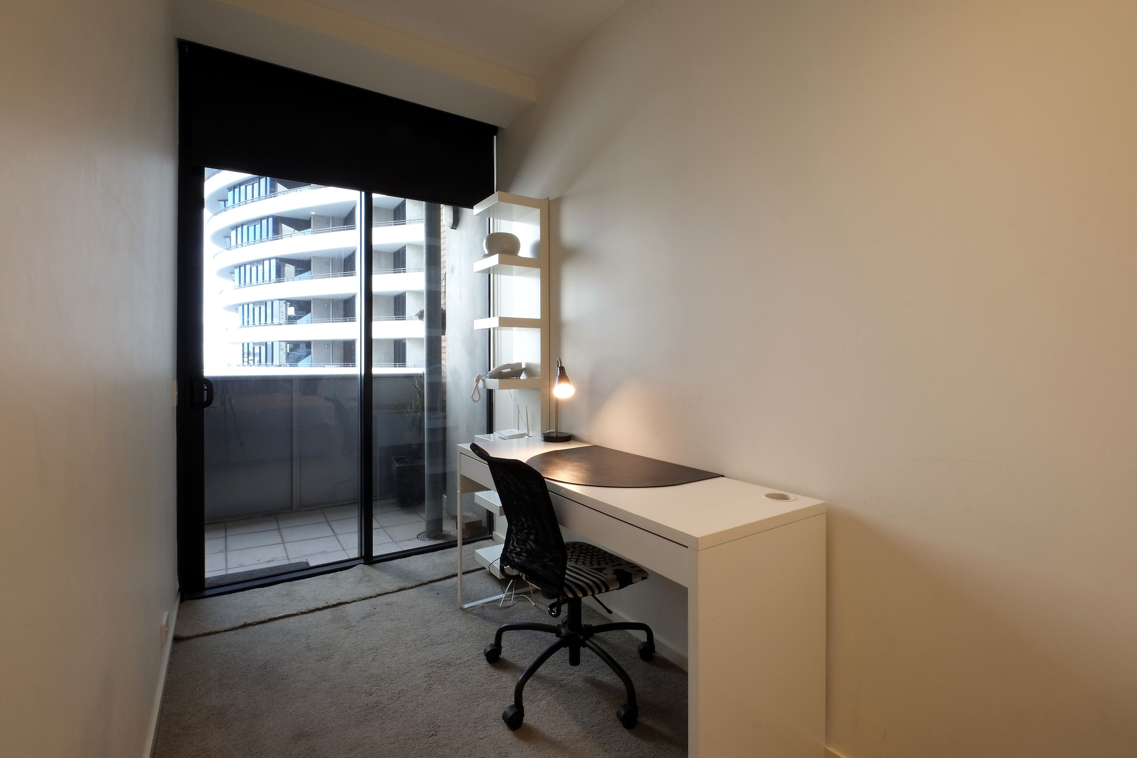 Un espace de bureau moderne comprenant un bureau, une chaise et une étagère.