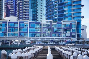 Un hotel frente al mar con arquitectura moderna, que cuenta con balcones y grandes ventanales.