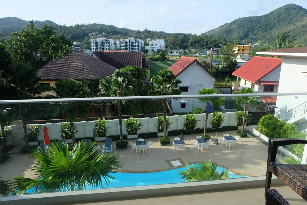 A pool area with lounge chairs and a view of surrounding buildings.