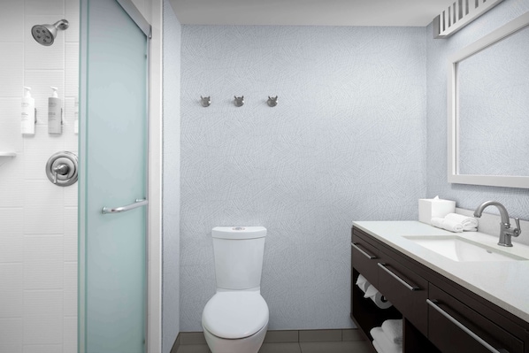 A modern bathroom with a toilet, sink, and shower.