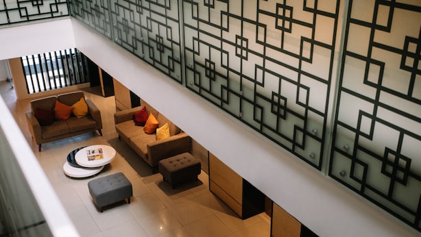 Un intérieur moderne avec un ensemble de canapés, un pouf et une table ronde.