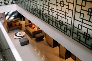 A modern interior with a sofa set, ottoman, and a round table. - Dynasty Tourist Inn (Cebu City)
