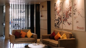 Un hall d’entrée moderne avec deux canapés, une table basse et un mur décoratif orné d’œuvres d’art.