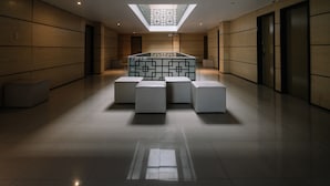 Un hall d’entrée moderne avec une verrière, un comptoir d’accueil et un espace salon.