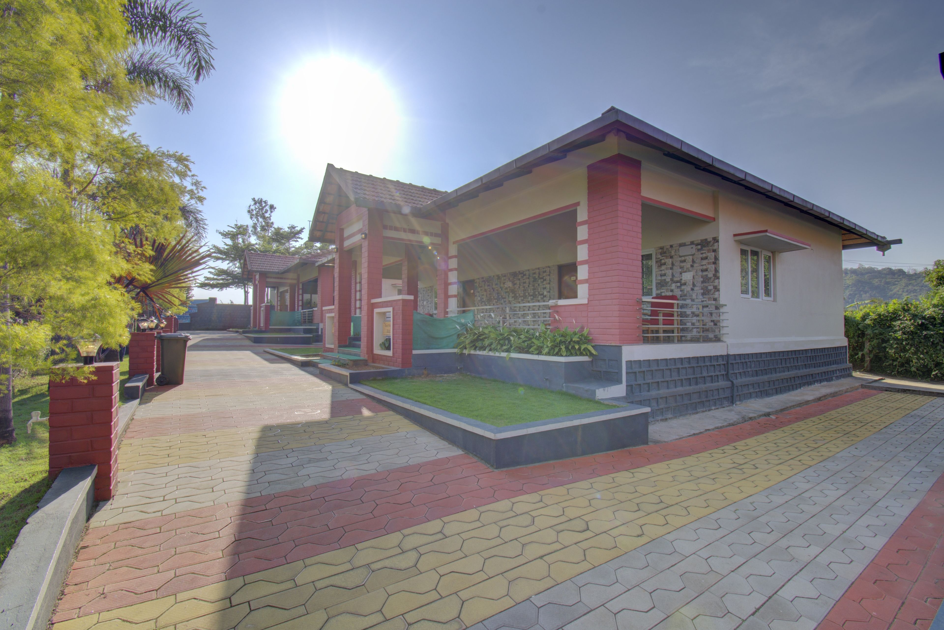 A modern building with a covered porch, a well-maintained lawn, and a paved walkway.