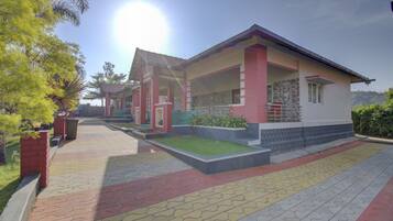 A modern building with a covered porch, a well-maintained lawn, and a paved walkway.