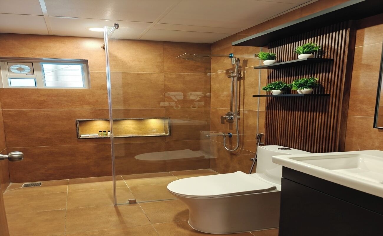 A modern bathroom with a glass-enclosed shower, a white toilet, and a vanity with a mirror.