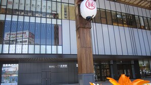 A modern building with large windows and a sign for 'NAGO STATION'. - Hotel Abest Nagano Ekimae (Nagano)