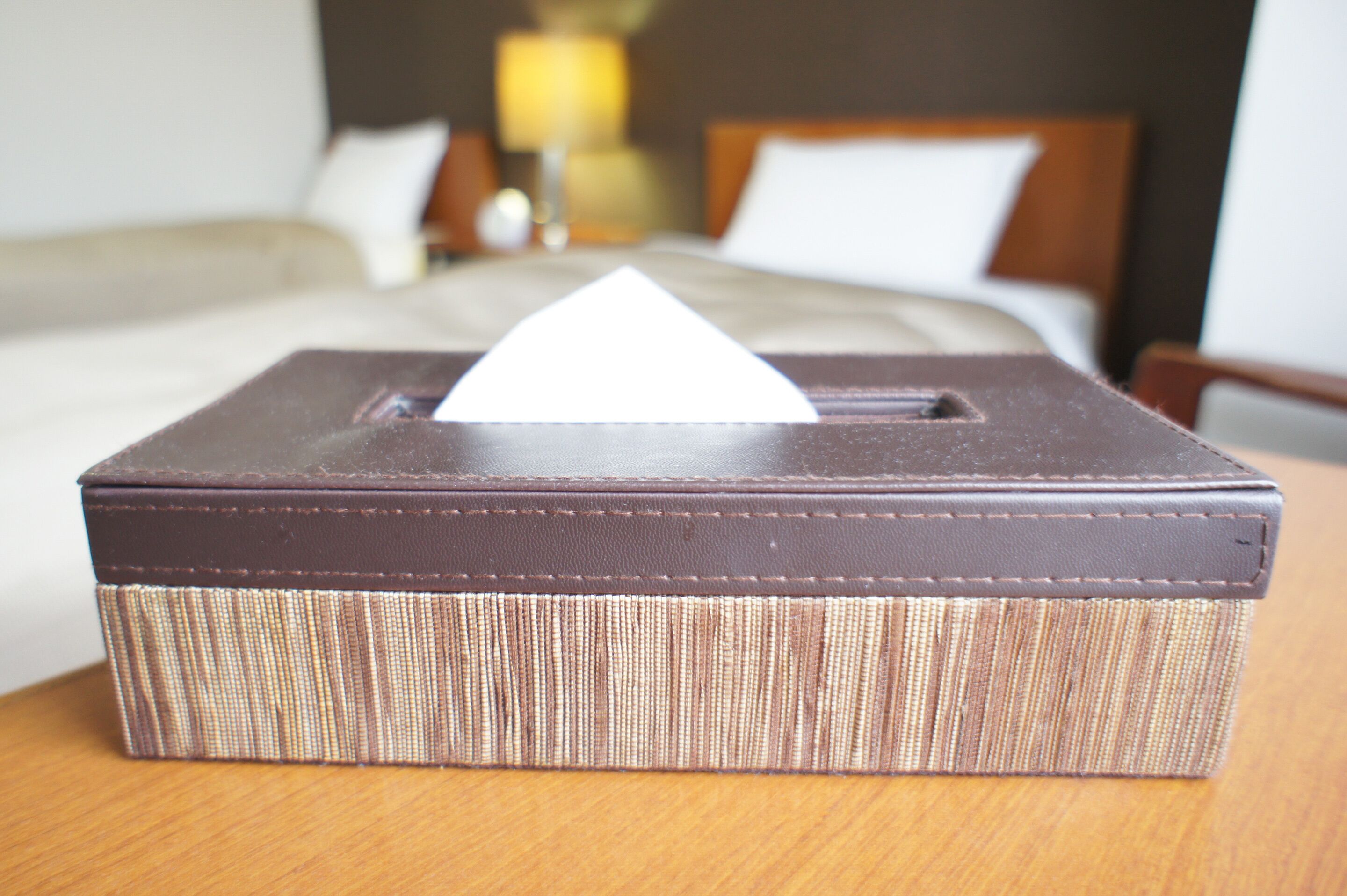 A tissue box on a wooden table in a hotel room.