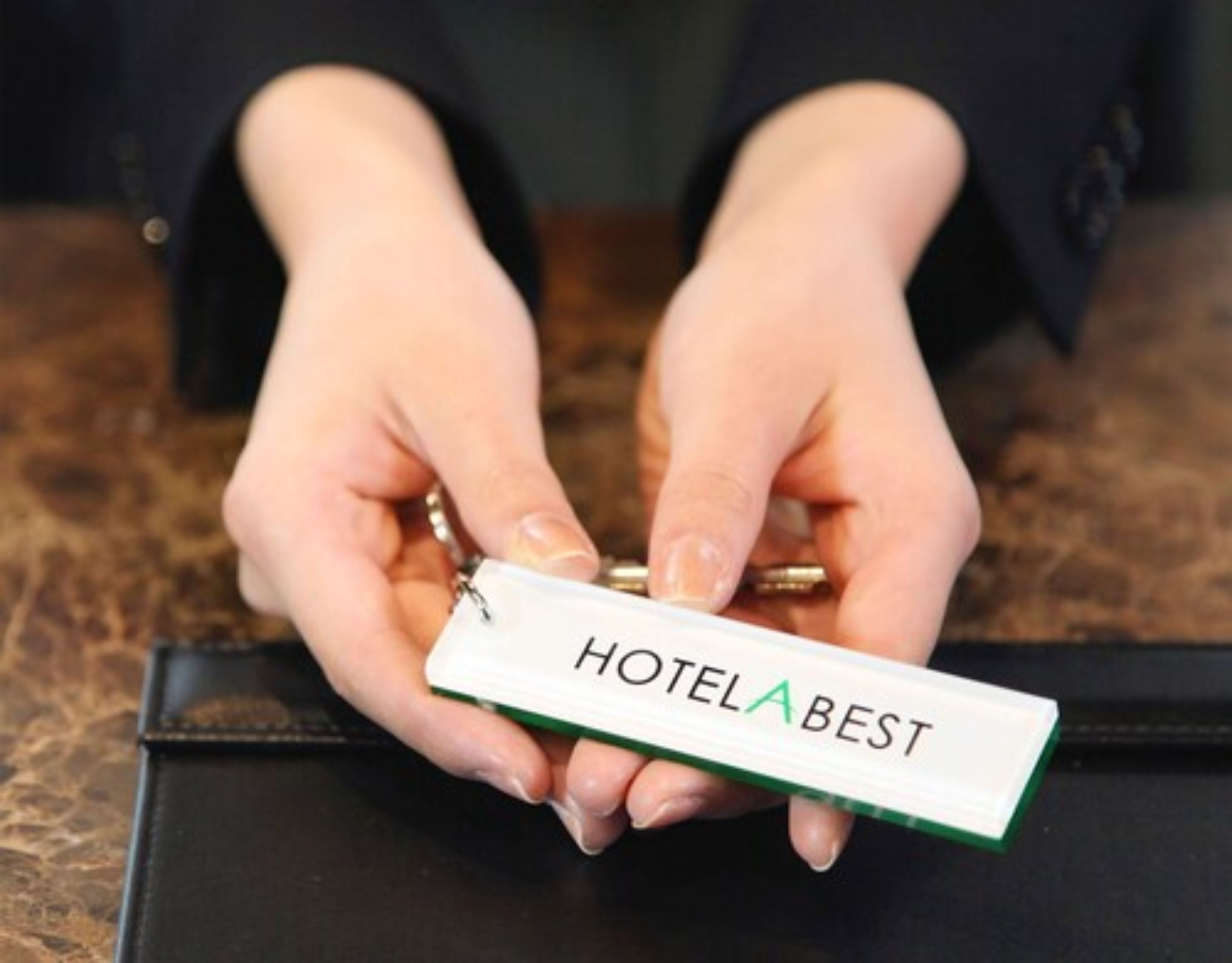 Une personne tenant une carte d’accès marquée du nom « HOTELABEST ».
