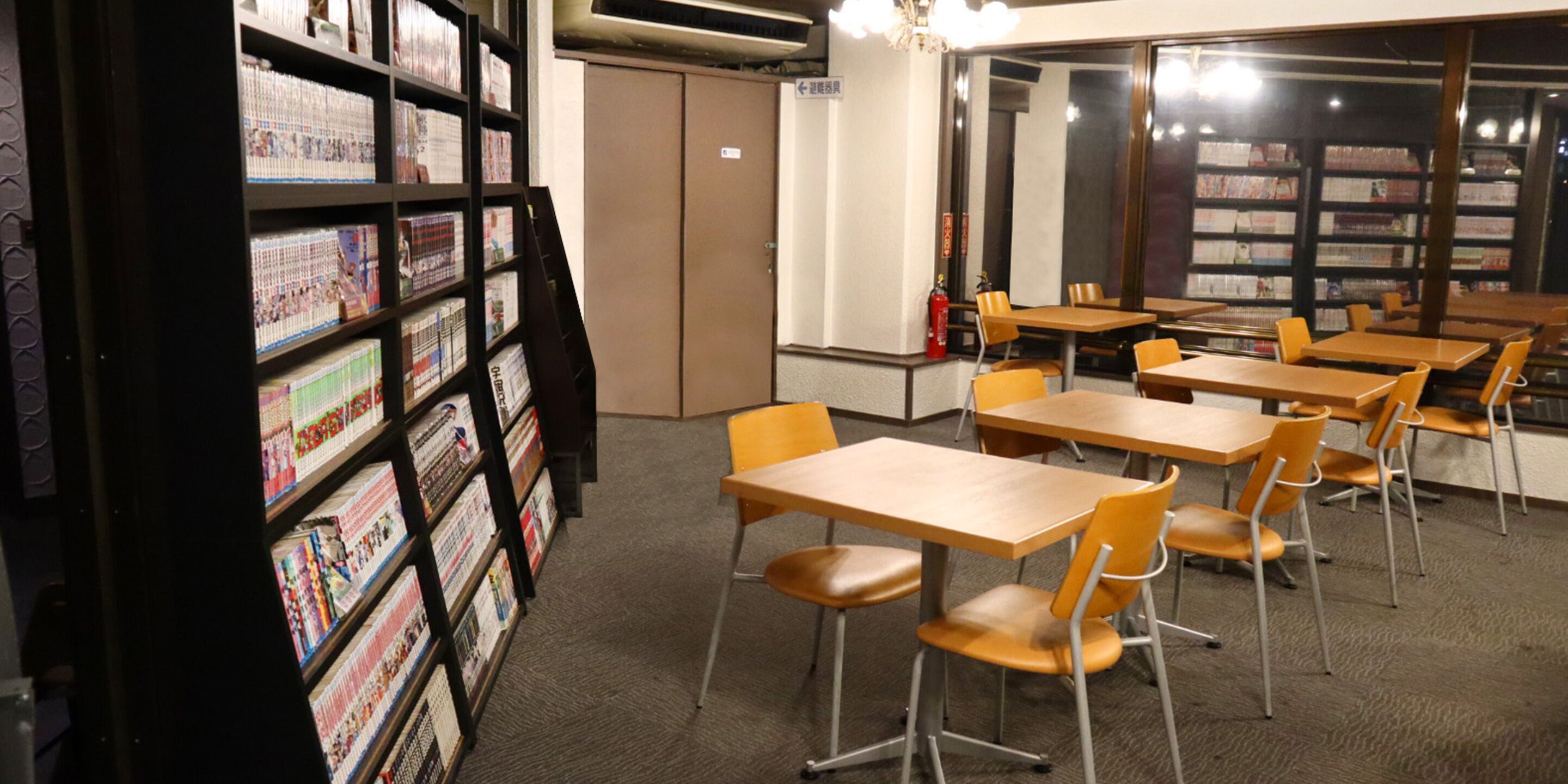 A library with bookshelves, tables, and chairs.