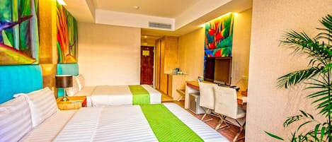 A hotel room with two beds, a desk, a chair, a television, and a plant.