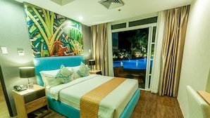 Habitación de hotel con cama, mesita de noche, un cuadro y vistas a una piscina al aire libre.
