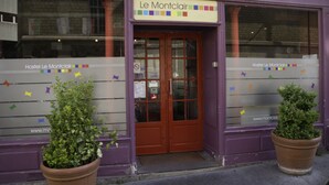 Un bâtiment sur lequel on peut lire l’inscription « Auberge Le Montclair », ainsi que l’adresse de son site web. Deux plantes en pot sont placées devant l’entrée.