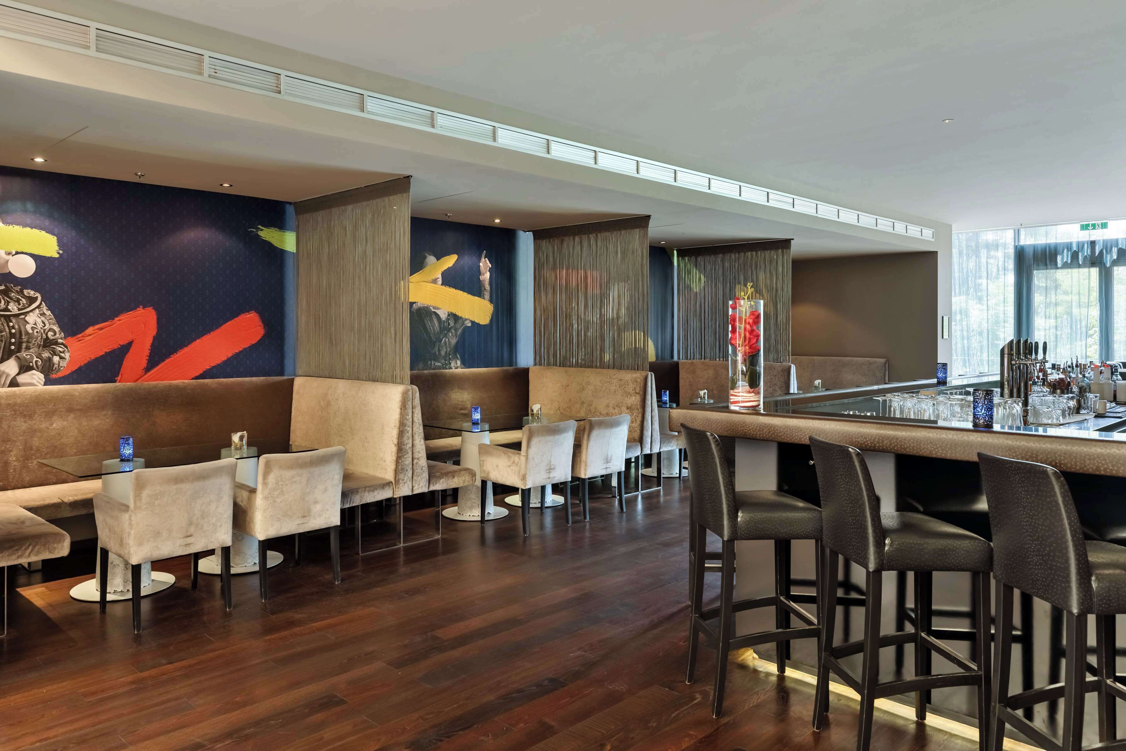 A modern bar area with seating and a bar counter.
