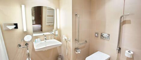 A modern bathroom with a sink, mirror, toilet, and shower.