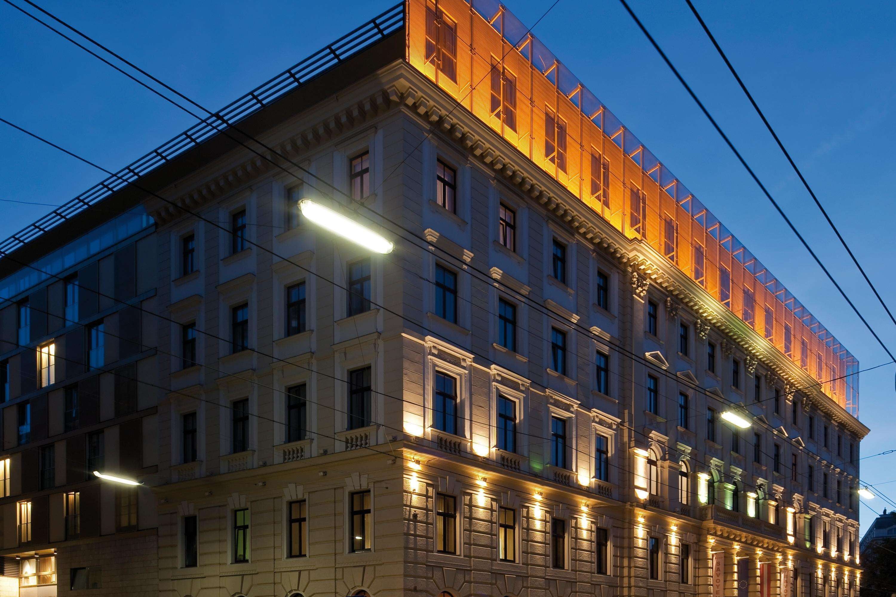 A multi-story building with a classical architectural style, featuring a prominent balcony on the second floor and a series of evenly spaced windows.