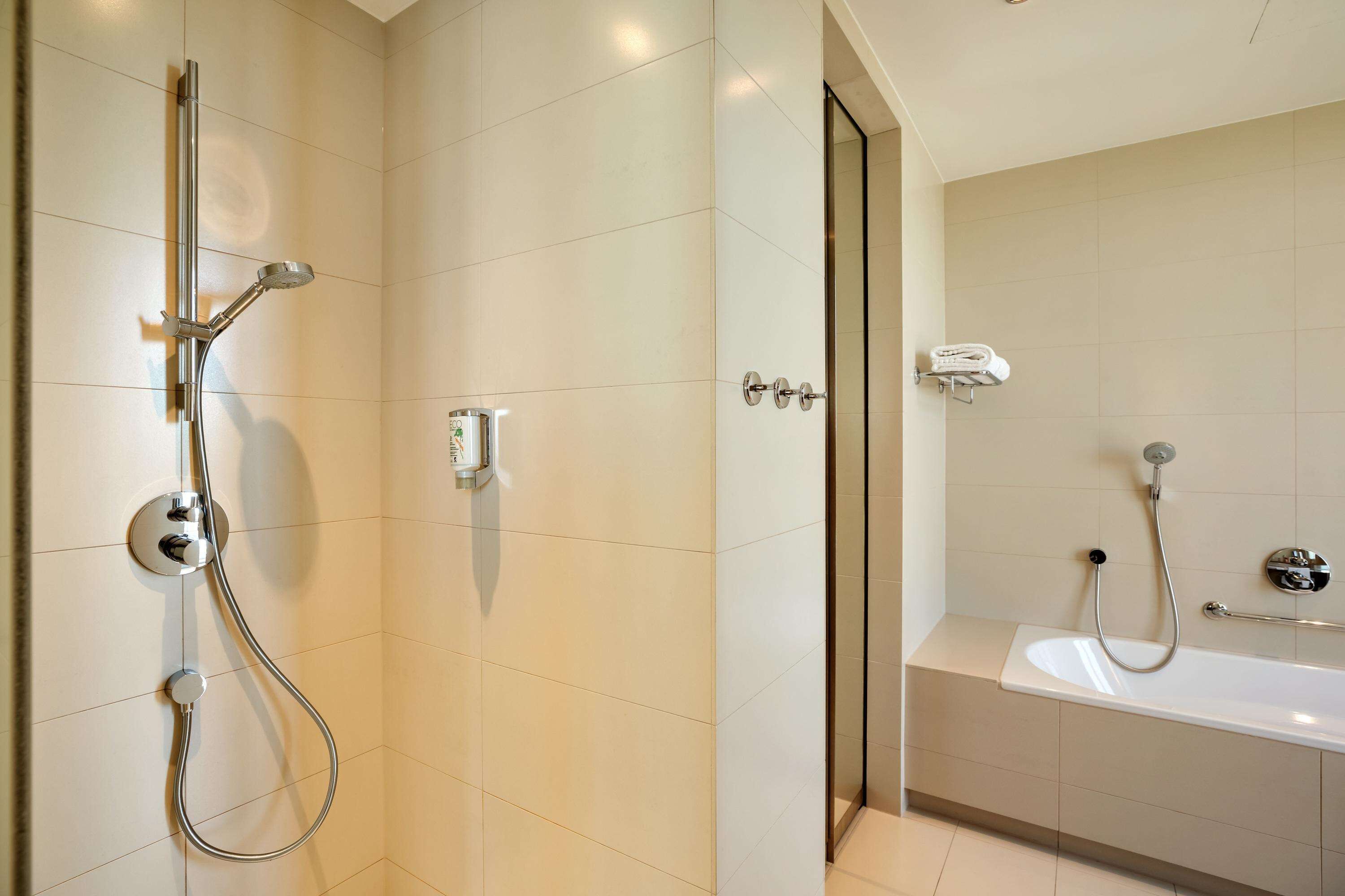 Une salle de bain moderne équipée d’une douche, d’une baignoire et de toilettes.