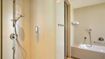 Een moderne badkamer met een douche, een bad en een toilet.