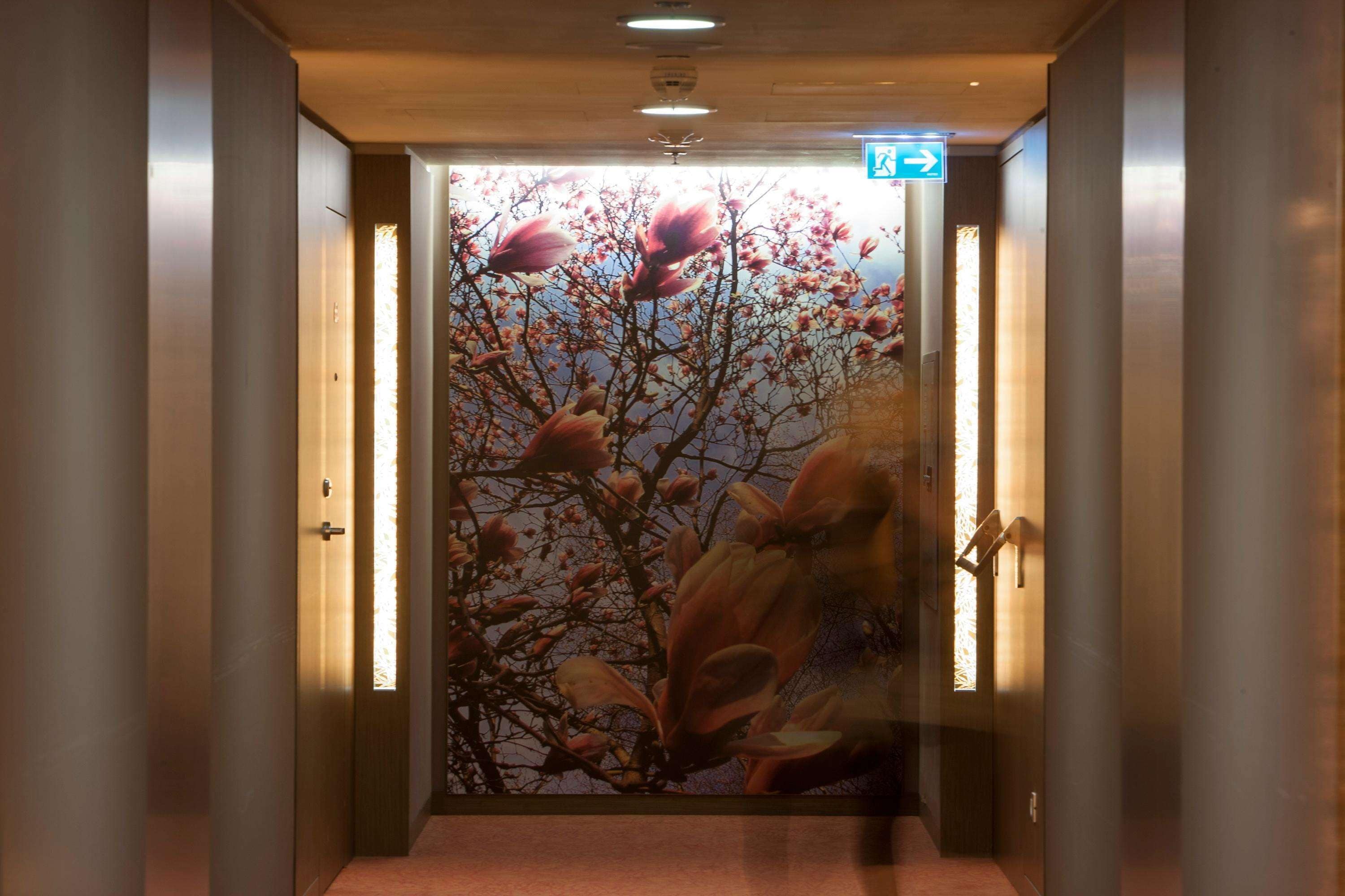 Un pasillo con una puerta decorada con un mural floral.