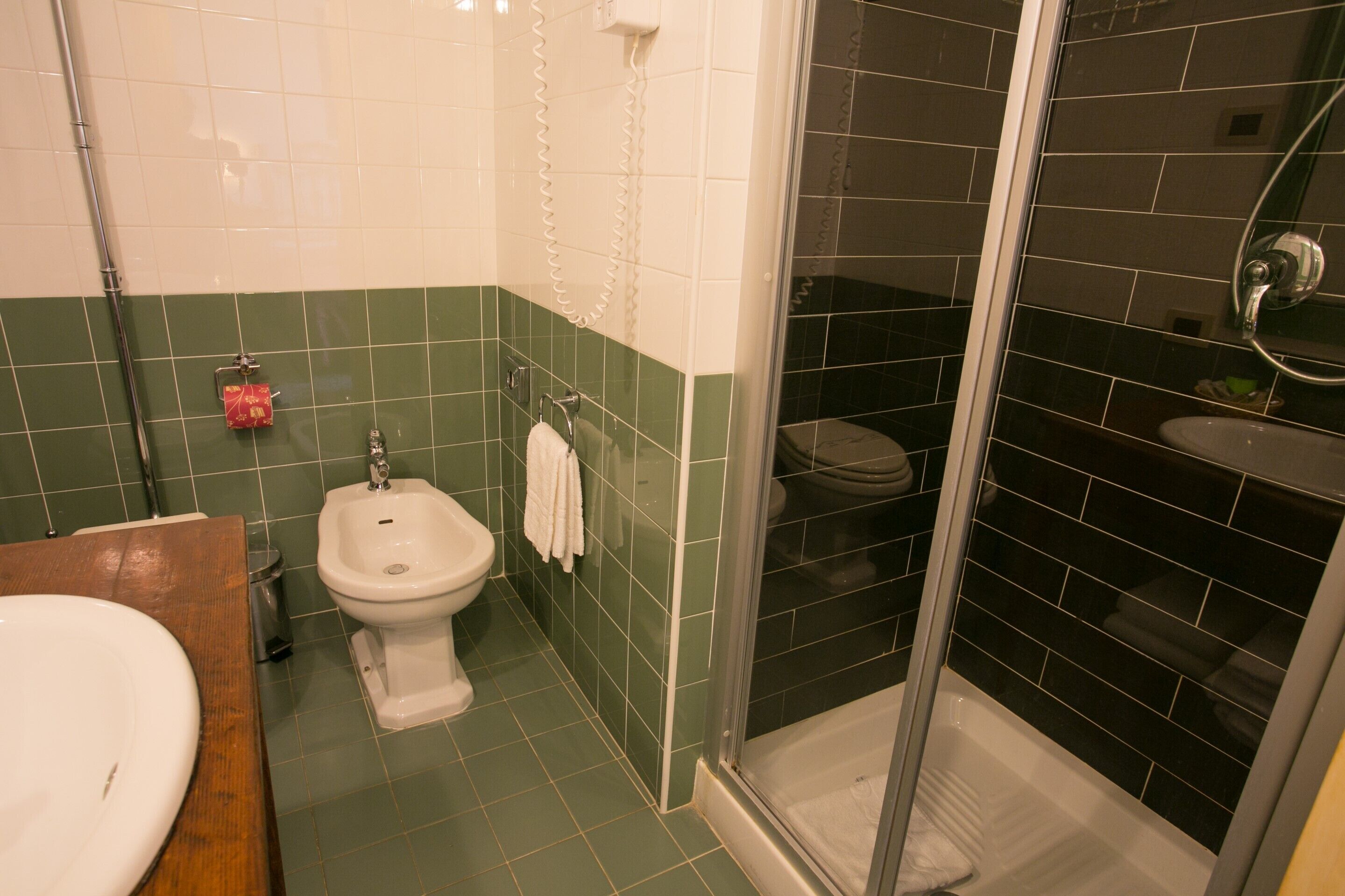 Un baño con ducha, inodoro, bidé y lavamanos.