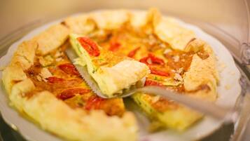 A pizza with a golden crust and toppings, served on a clear glass plate.