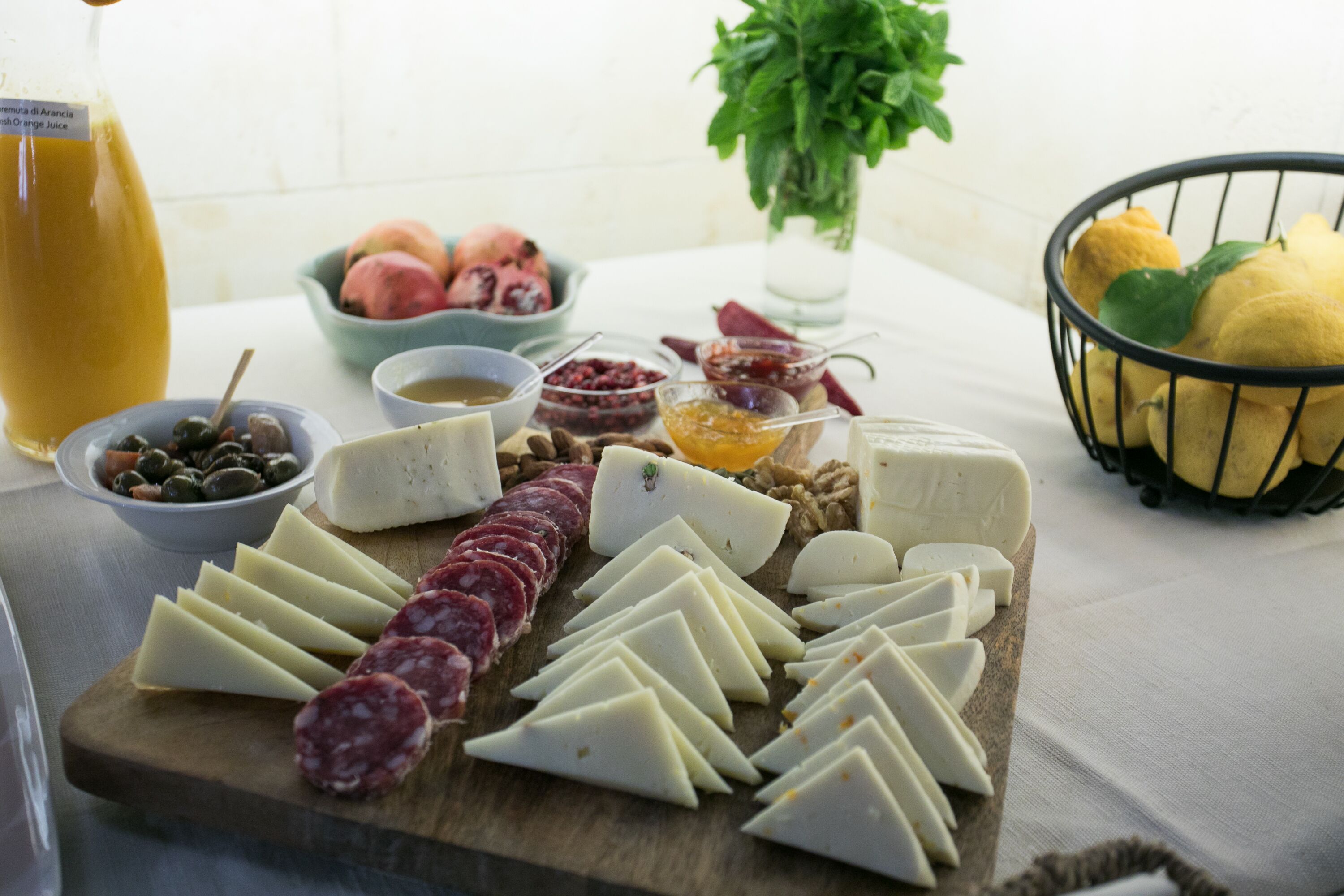 Une planche de charcuterie comprenant divers fromages, viandes séchées et fruits.