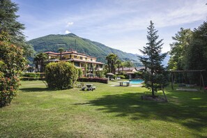 A hotel with a pool, outdoor seating, and a mountain backdrop.