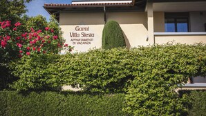 A building with a sign reading 'Garni Villa Siesta APARTMENTI DI VACANZA.' - Villa Siesta, Park & Pool Living (Losone)