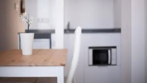 A modern kitchen with white cabinetry, a wooden countertop, and a small window. - Hotel Sol Playa (Valencia)