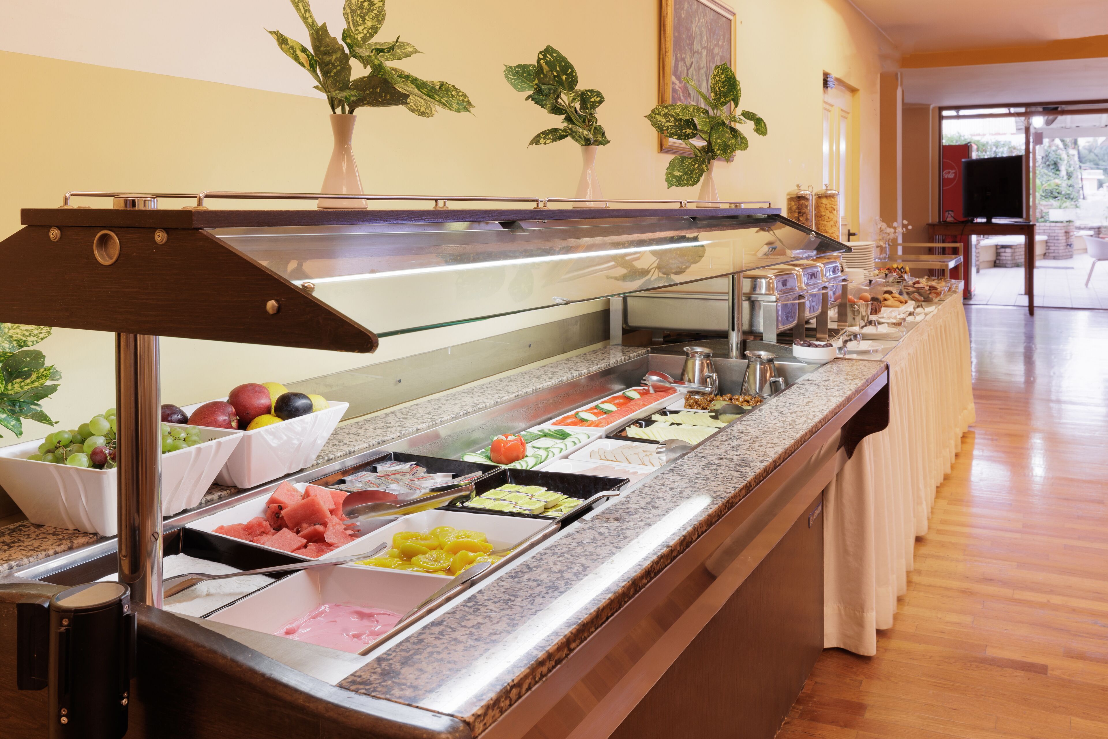 A buffet with various food items and a television in the background.