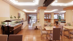 A spacious restaurant with a buffet, multiple seating areas, and a pool table. - Louvre Hotel (Corfu)