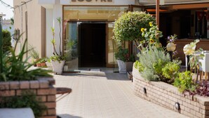 A hotel entrance with a sign reading "HOTEL LOUVRE". - Louvre Hotel (Corfu)